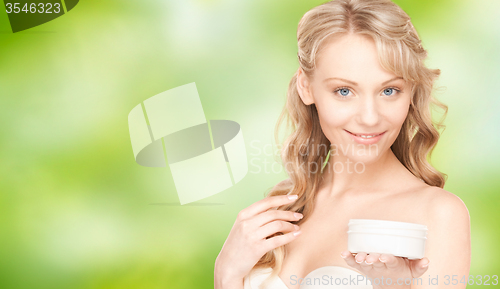 Image of smiling woman cleaning face skin with cotton pad