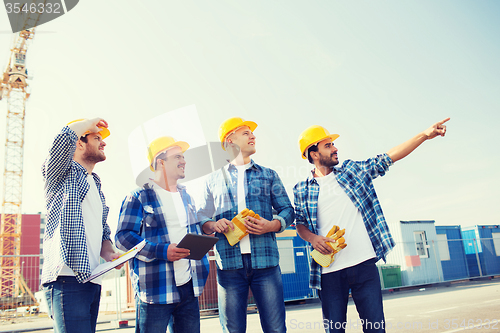 Image of group of smiling builders with tablet pc outdoors