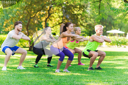 Image of group of friends or sportsmen exercising outdoors