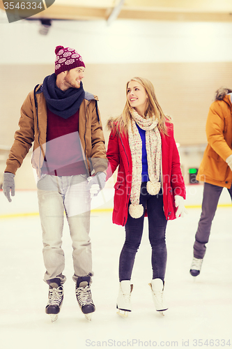 Image of happy couple holding hands on skating rink