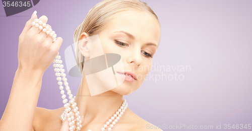 Image of beautiful woman with pearl necklace over violet