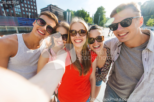 Image of smiling friends taking selfie