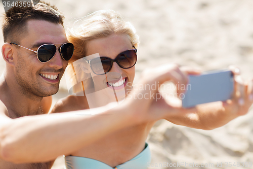 Image of happy couple in swimwear walking on summer beach