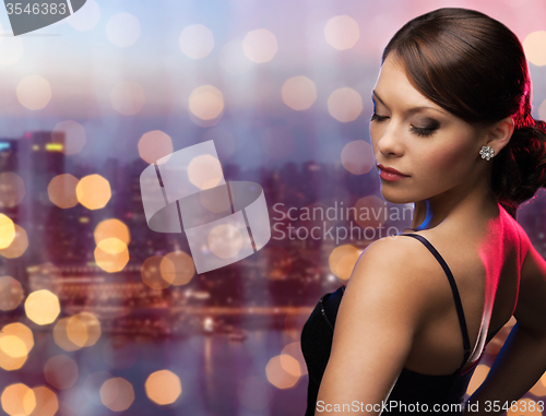 Image of woman with diamond earring over night city