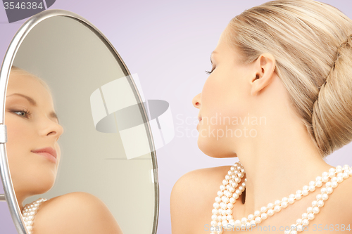 Image of beautiful woman with pearl necklace and mirror