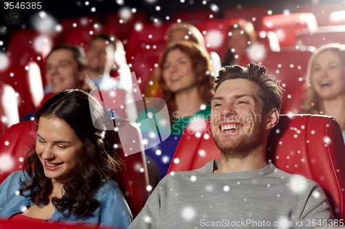 Image of happy friends watching movie in theater