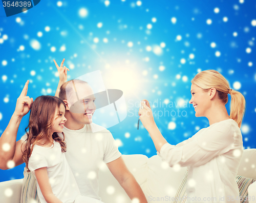 Image of happy family with camera at home