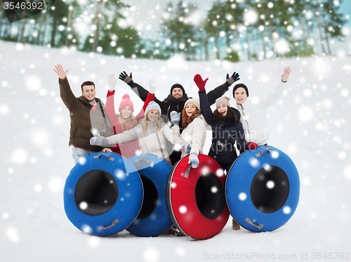 Image of group of smiling friends with snow tubes