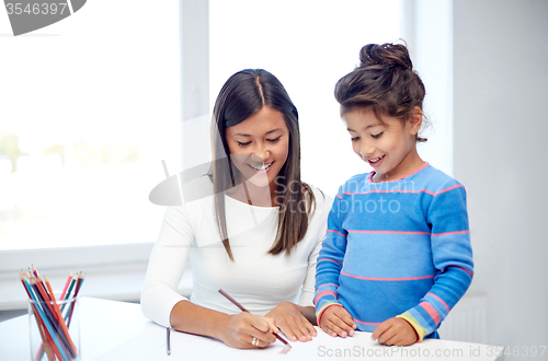 Image of happy mother and daughter drawing with pencils