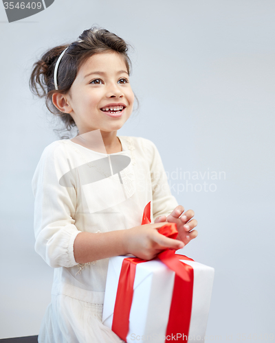 Image of happy little girl with gift box at home