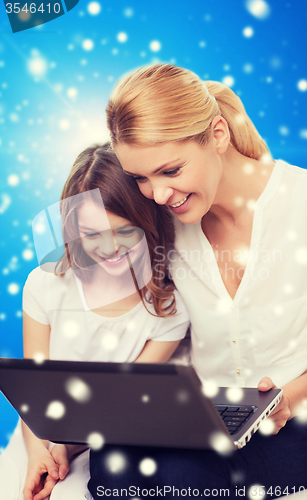 Image of smiling mother and little girl with laptop