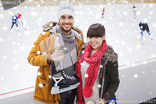 Image of happy couple with ice-skates on skating rink