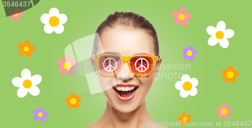 Image of happy teenage hippy girl in shades with peace sign