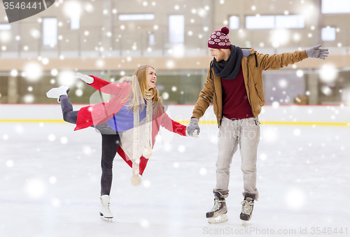 Image of happy couple holding hands on skating rink