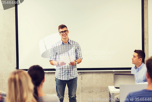 Image of group of smiling students and teacher in classroom