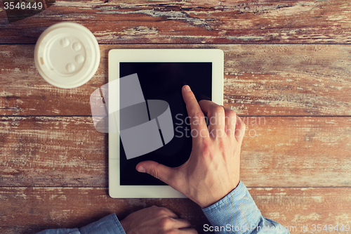 Image of close up of male hands with tablet pc and coffee