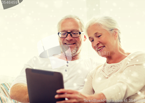Image of happy senior couple with tablet pc at home