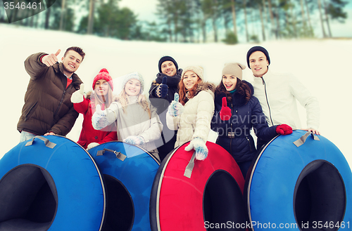 Image of group of smiling friends with snow tubes