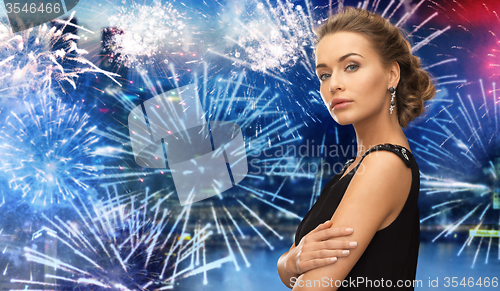 Image of beautiful woman wearing earrings over firework