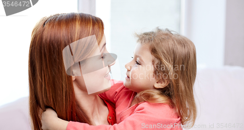 Image of happy mother and little daughter hugging at home