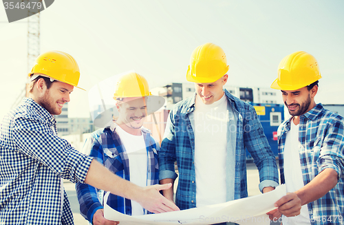 Image of group of builders with tablet pc and blueprint