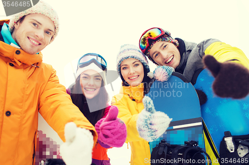 Image of happy friends with snowboards showing thumbs up