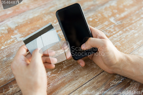 Image of close up of hands with smart phone and credit card