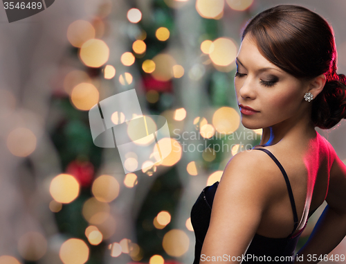 Image of woman with diamond earring over christmas lights