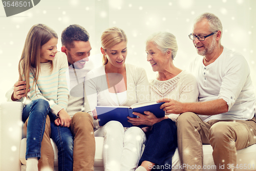 Image of happy family with book or photo album at home