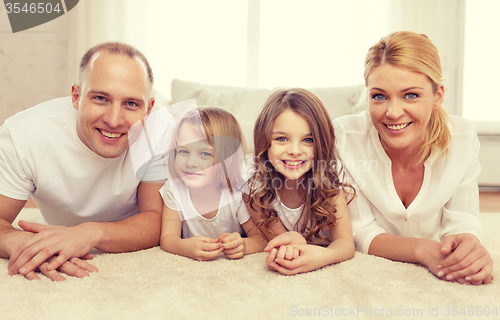Image of parents and two girls lying on floor at home