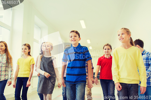 Image of group of smiling school kids walking in corridor