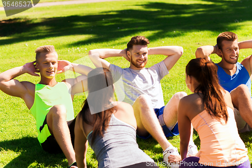 Image of group of friends or sportsmen exercising outdoors