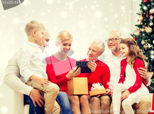 Image of smiling family with tablet pc and gift box at home