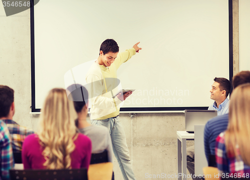 Image of group of smiling students and teacher in classroom