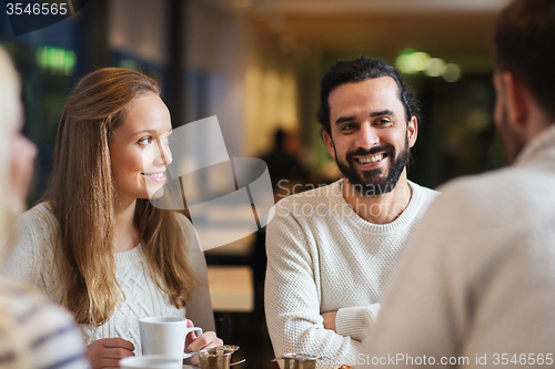 Image of happy friends meeting and drinking tea or coffee