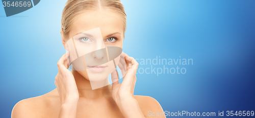 Image of beautiful young woman touching her neck