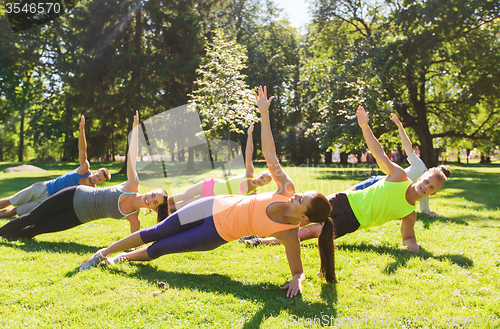 Image of group of happy friends exercising outdoors