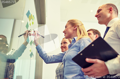 Image of smiling business people with marker and stickers