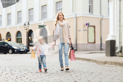 Image of happy mother and child with shopping bags in city
