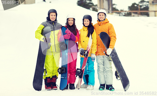 Image of happy friends in helmets with snowboards