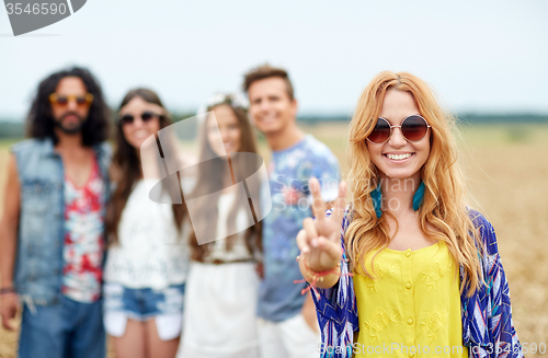 Image of happy young hippie friends showing peace outdoors