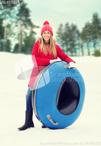 Image of happy teenage girl or woman with snow tube