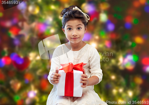 Image of happy little girl with present over lights