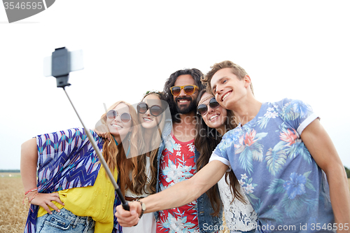 Image of hippie friends with smartphone on selfie stick