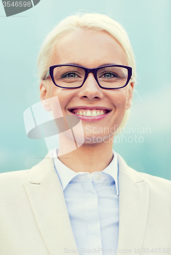 Image of young smiling businesswoman over office building