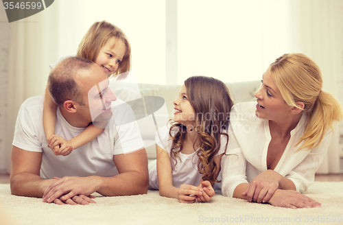 Image of parents and two girls lying on floor at home