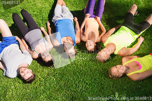 Image of group of happy sporty friends in circle outdoors