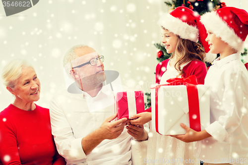Image of smiling family with gifts at home