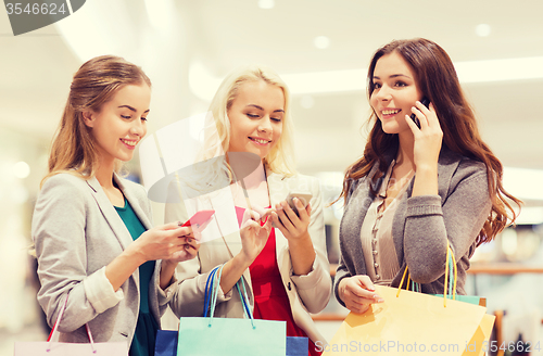 Image of happy women with smartphones and shopping bags