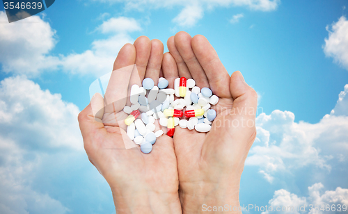 Image of close up of senior woman hands with pills